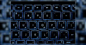 Imagem de parte de um teclado, com fundo de led, focando nos caracteres especiais.