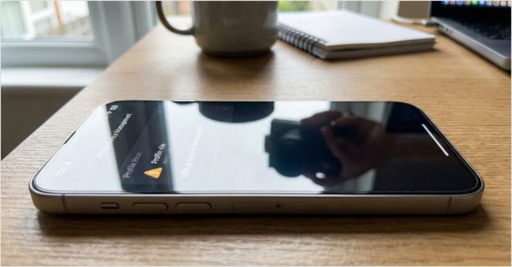 iPhone moderno em uma mesa exibindo as configurações de VPN e gerenciamento de dispositivos com ícone de alerta para segurança no iPhone.